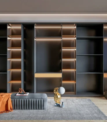 Bespoke dark grey modular shelving unit by BNG Interiors featuring integrated LED backlighting, wooden drawer accents, and a modern grey ottoman in a luxury interior