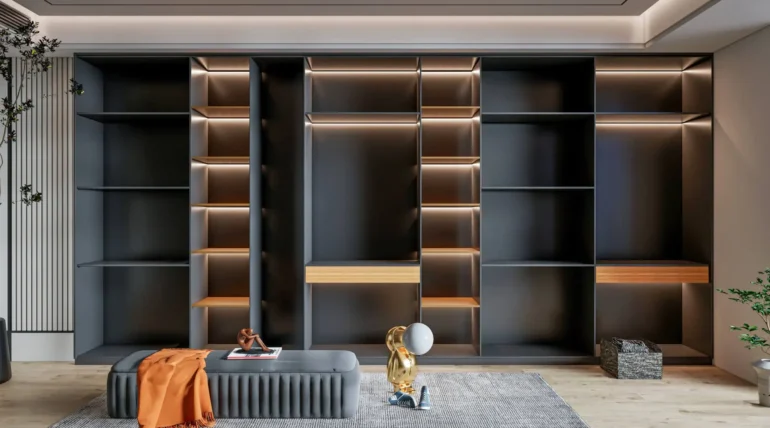 Bespoke dark grey modular shelving unit by BNG Interiors featuring integrated LED backlighting, wooden drawer accents, and a modern grey ottoman in a luxury interior