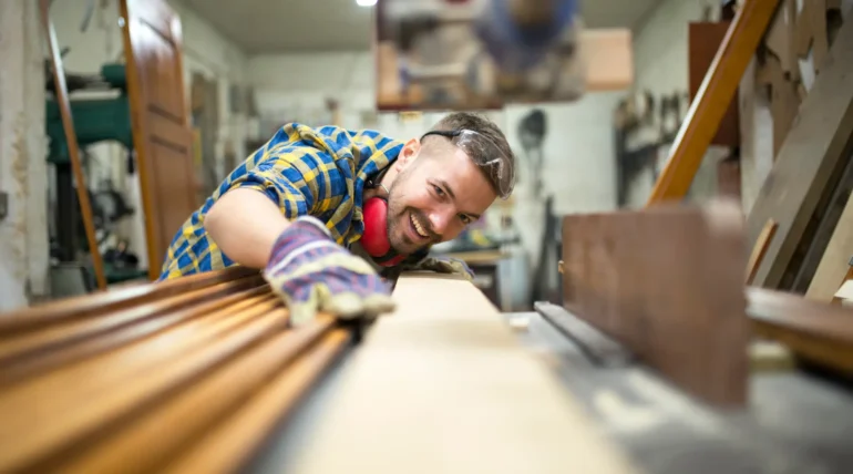 Wood furniture manufacturing process with skilled carpenter shaping custom wooden pieces in woodworking workshop.
